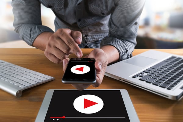 Man in front of video recording devices